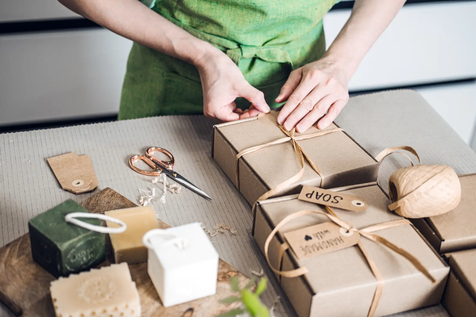 Gros plan sur des matériaux d'emballage recyclables : carton kraft, papier de calage et insert moulé disposés sur une surface en bois.